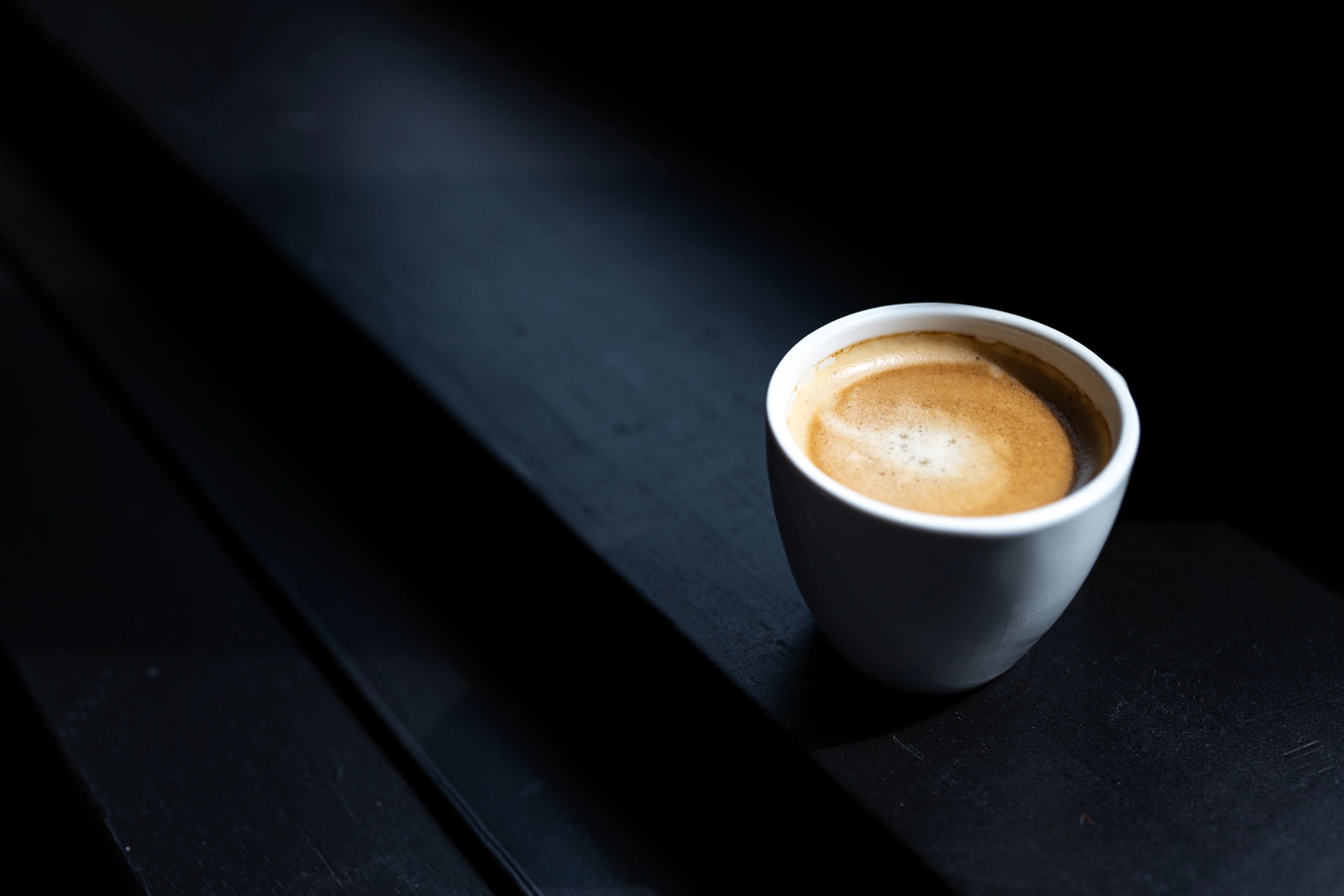 Coffee capsules beside a cup of coffee